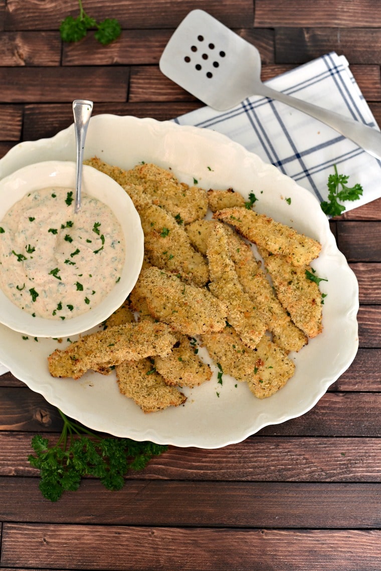 A platter of panko breaded chicken strips with a bowl of creole dipping sauce