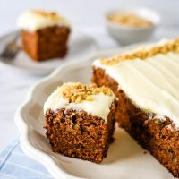 piece of carrot cake on platter with cake