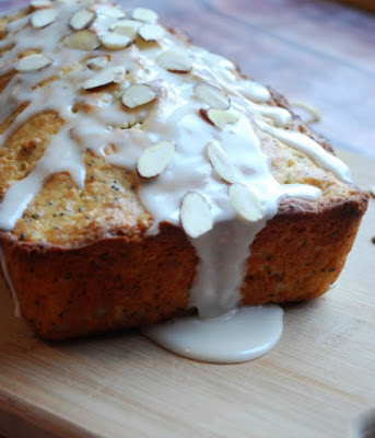 Close up of one end of almond poppy seed bread with icing and sliced almonds