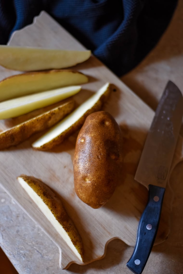 potatoes being sliced into wedges