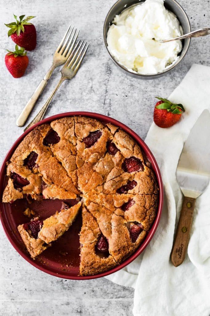 pie plate with strawberry cake with whipped cream on the side