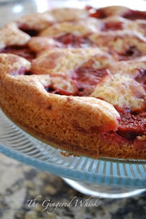 plum torte on glass cake stand