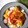 Sweet and Sour Kielbasa on blue grey plate with fork