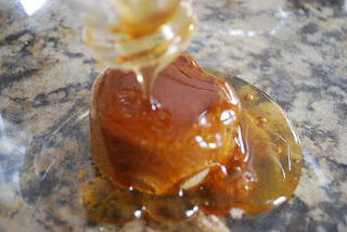honey being poured over brown sugar in glass bowl