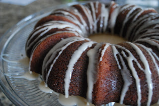 chocolate bundt cake with icing drizzle on glass serving plate