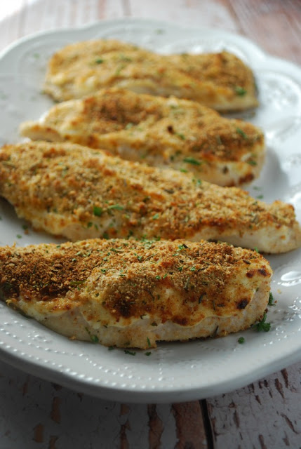 white platter filled with four pieces of parmesan crusted chicken breasts