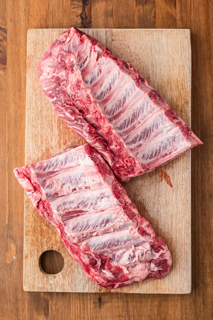two baby back ribs on cutting board