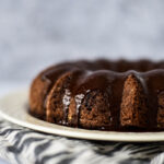 close up view of sourdough bundt cake with chocolate ganache drizzled on top