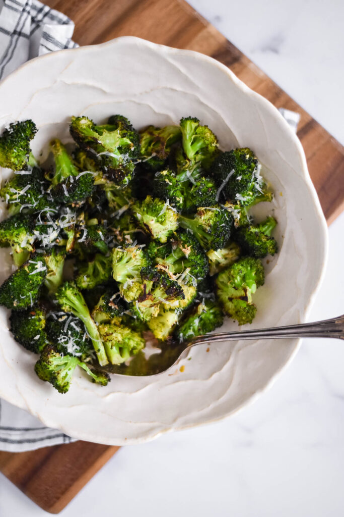 roasted broccoli in white serving bowl with spoon