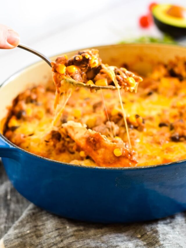 spoon pulling cheesy serving out of casserole dish