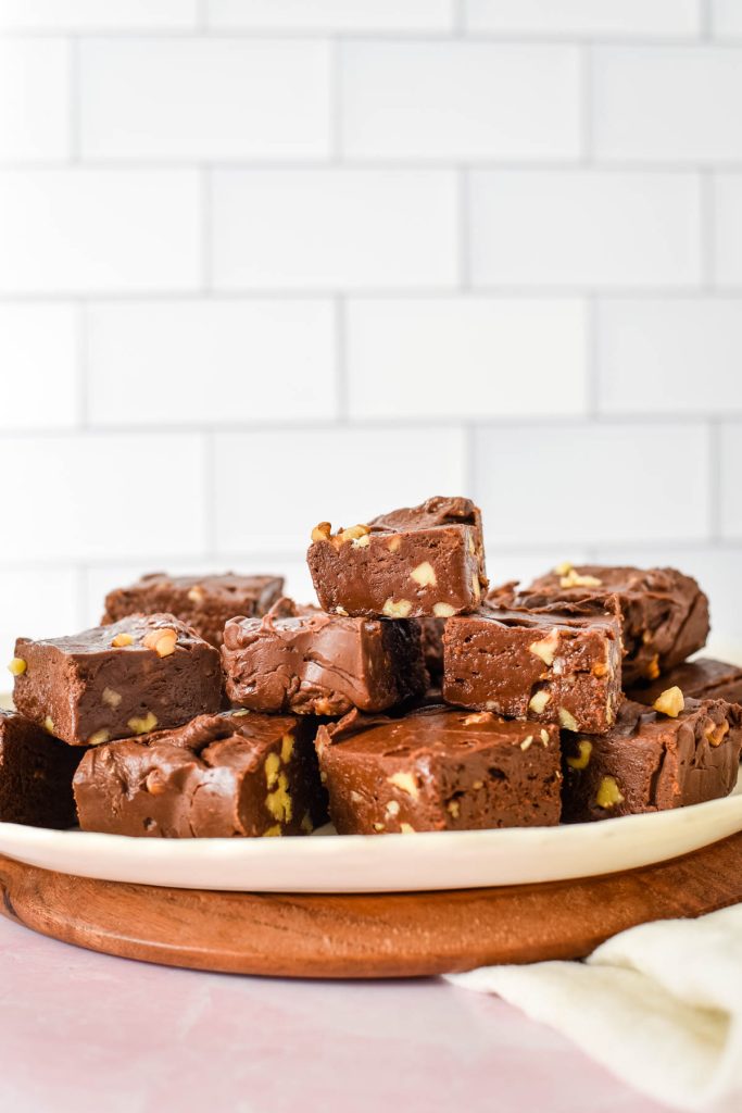 side view of white platter stacked with chocolate walnut fudge