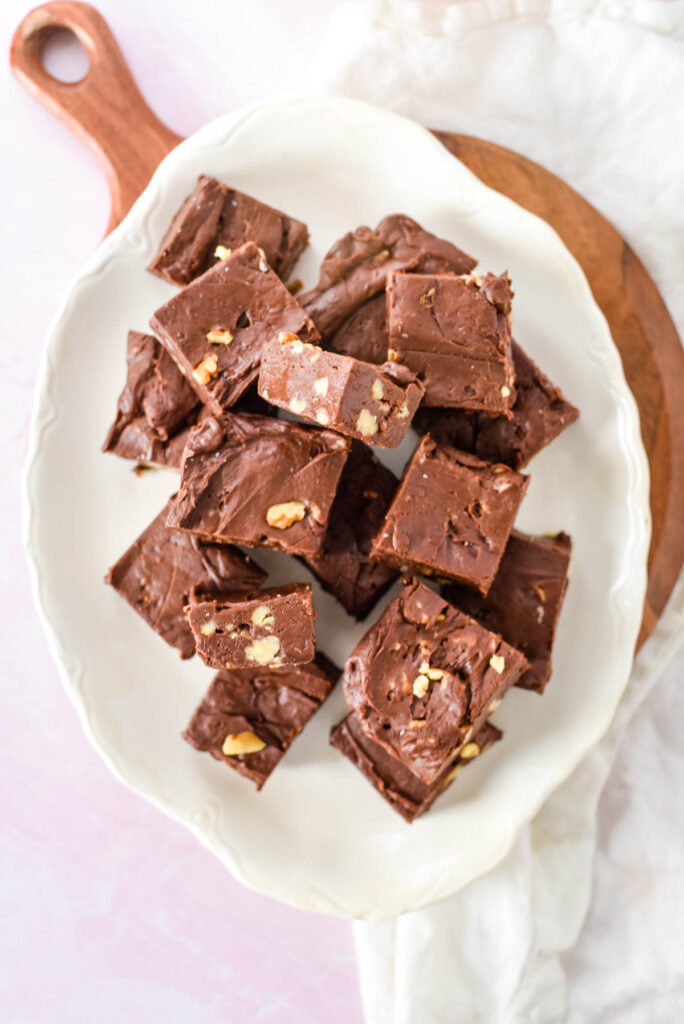 white platter filled with squares of chocolate fudge with walnuts