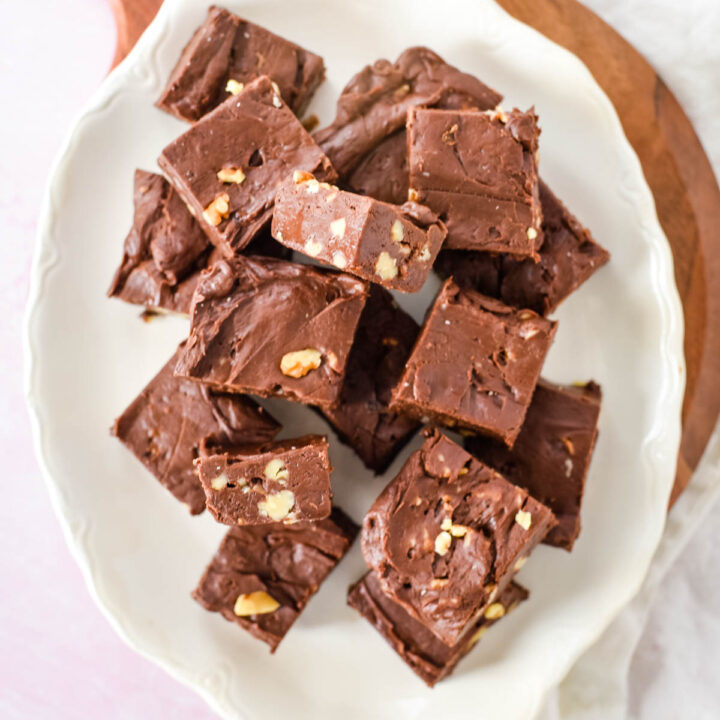white platter filled with squares of chocolate fudge with walnuts