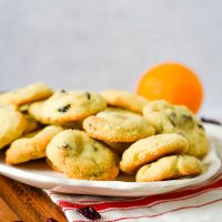 platter of cookies with oranges and cranberries beside