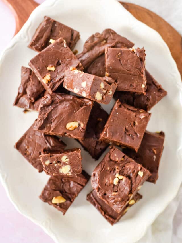 white platter filled with squares of chocolate fudge with walnuts