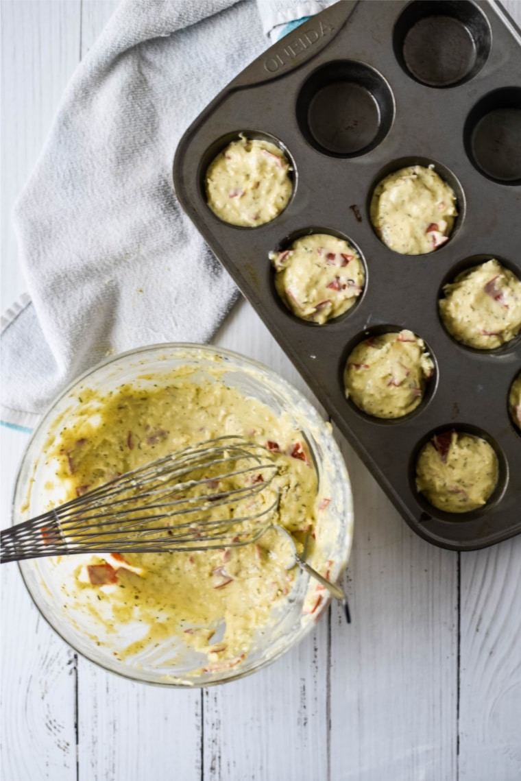 batter for pizza bites being put into muffin tin