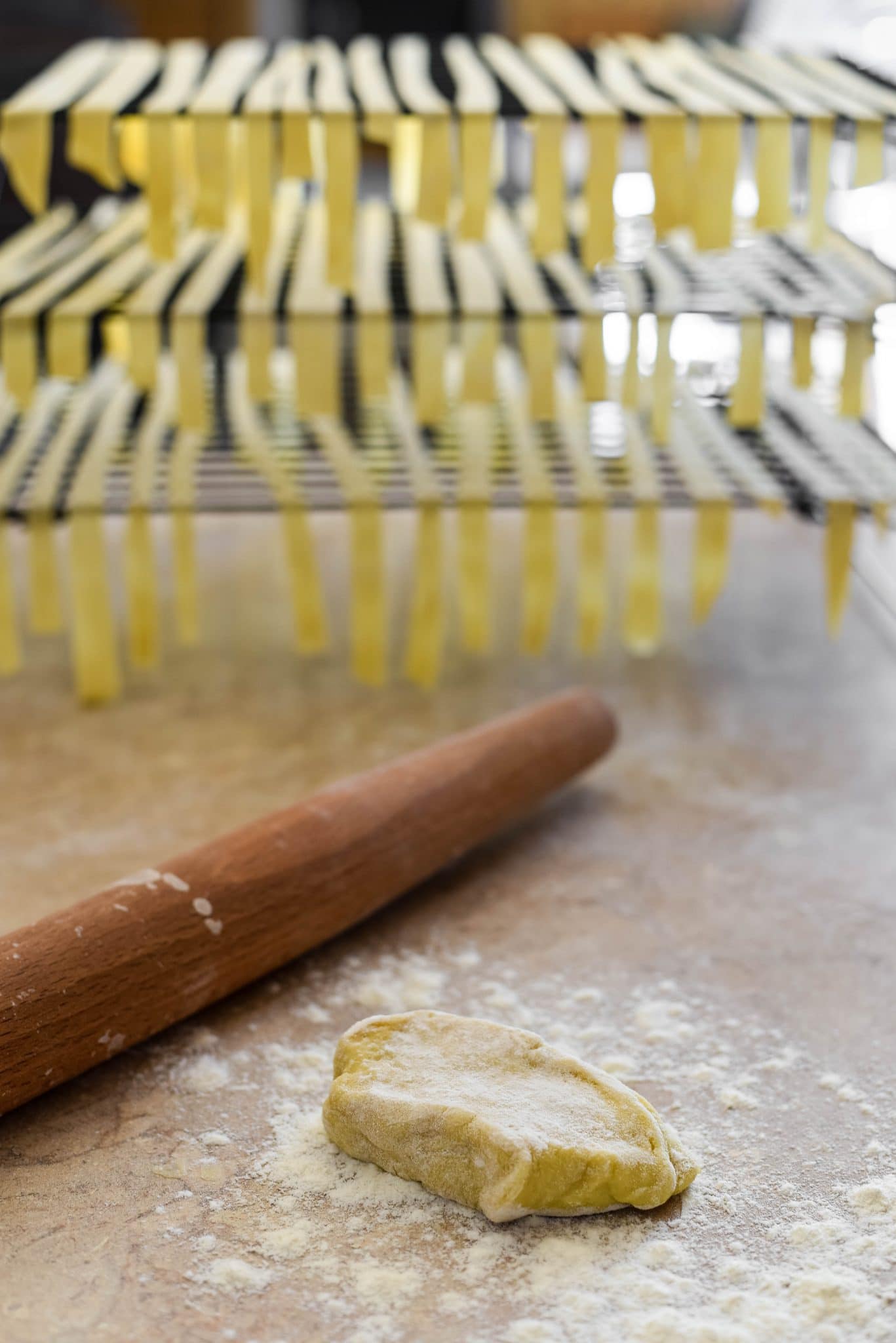 rolling sourdough pasta with drying racks in background