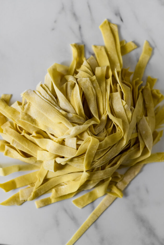 a pile of sourdough pasta noodles on marble