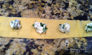 homemade pasta being rolled into ravioli and balls of cheese filling