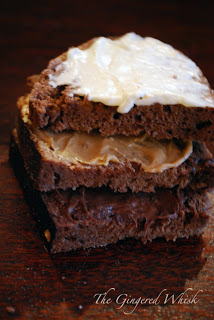 three slices of chocolate bread stacked, smeared with nutella, peanut butter, and cream cheese