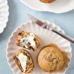 date walnut muffins cut open with butter on white plate