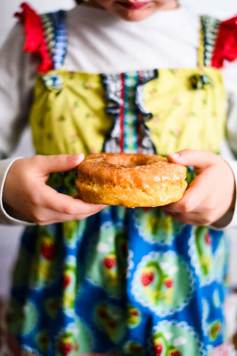 girl holding sourdough donut while wearing colorful dress