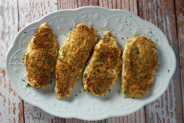 four chicken breasts on white platter