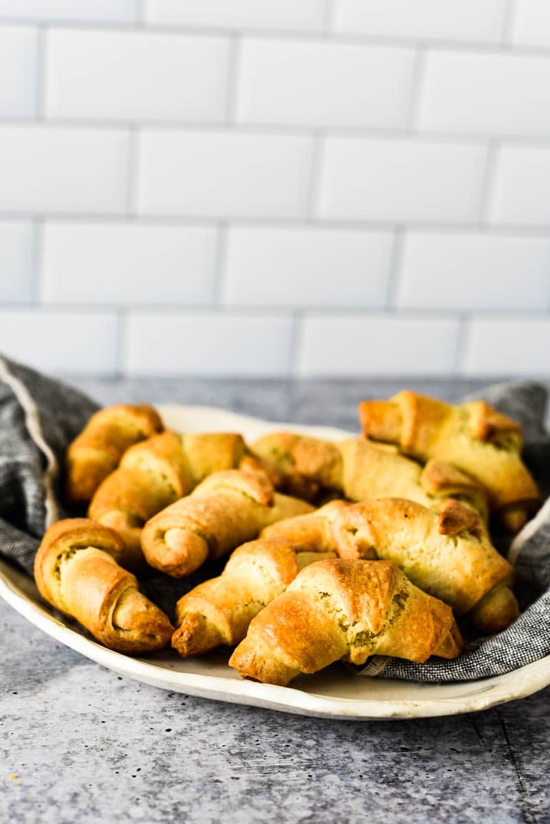 white dish fill grey napkin filled with sourdough crescent rolls