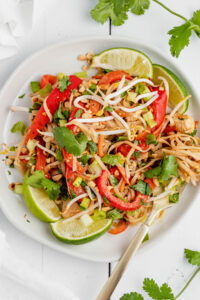 overhead view of white plate with rice noodles, veggies, and cilantro