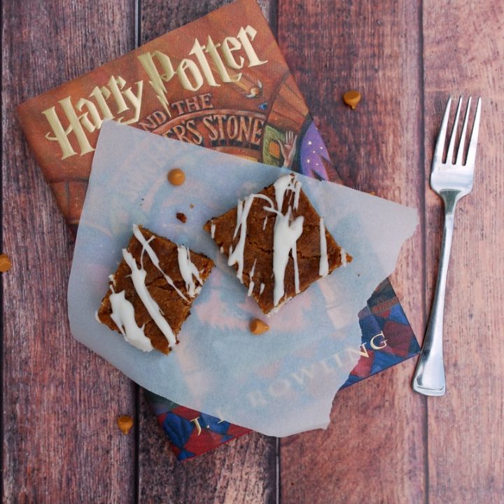 harry potter book with piece of parchment paper and two dessert bars on top. Fork beside book.