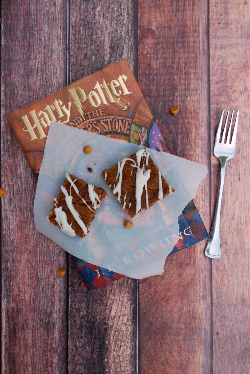 harry potter book with piece of parchment paper and two dessert bars on top. Fork beside book.