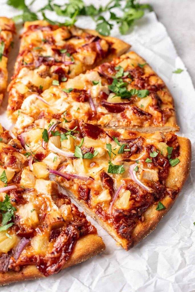 hawaiian bbq chicken pizza on counter with slices separated