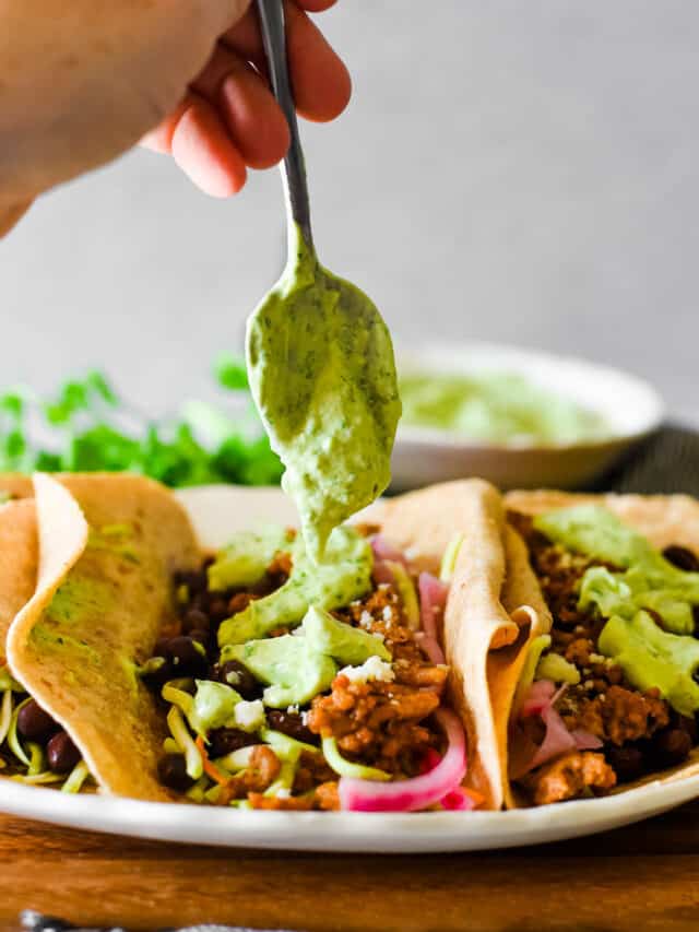 drizzling avocado crema on tacos