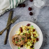 pork chops with cherry couscous on plate