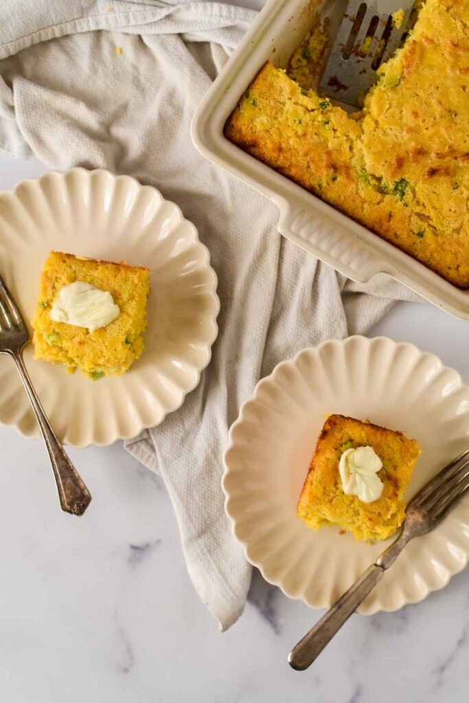 two plates with cornbread next to baking dish
