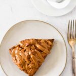sourdough scone on plate with tea and fork beside
