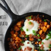 cast iron skillet with breakfast hash of sweet potatoes, black beans and eggs