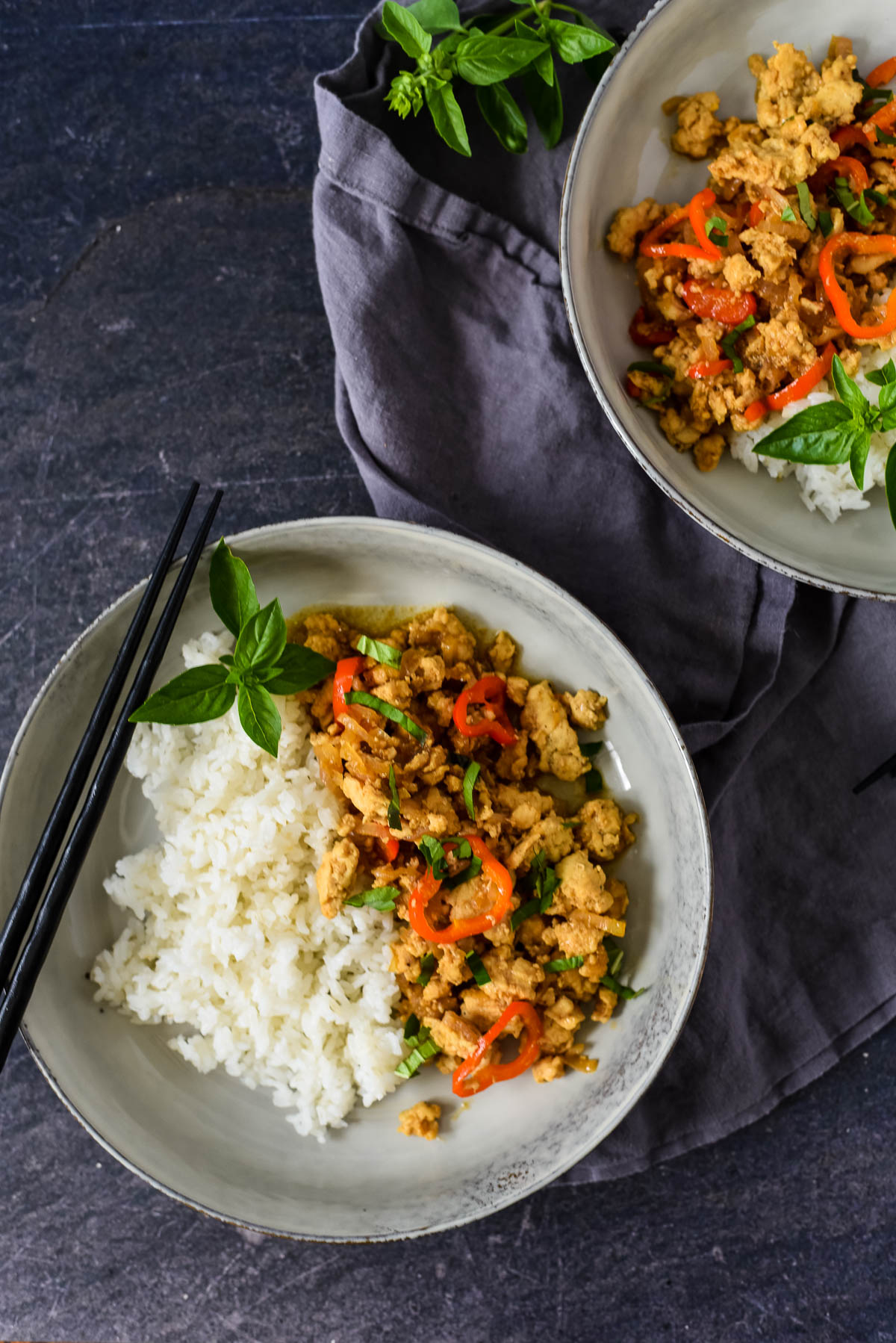 two plates with basil chicken and rice