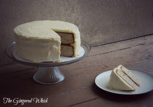 cake stand with earl grey cake and slice removed next to plate with slice