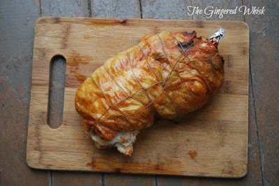 freshly baked chicken ballotine on wooden cutting board