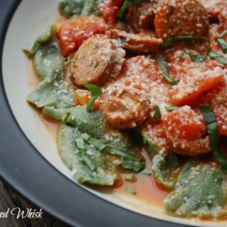 plate with homemade spinach ravioli and tomatoes and sausage 
