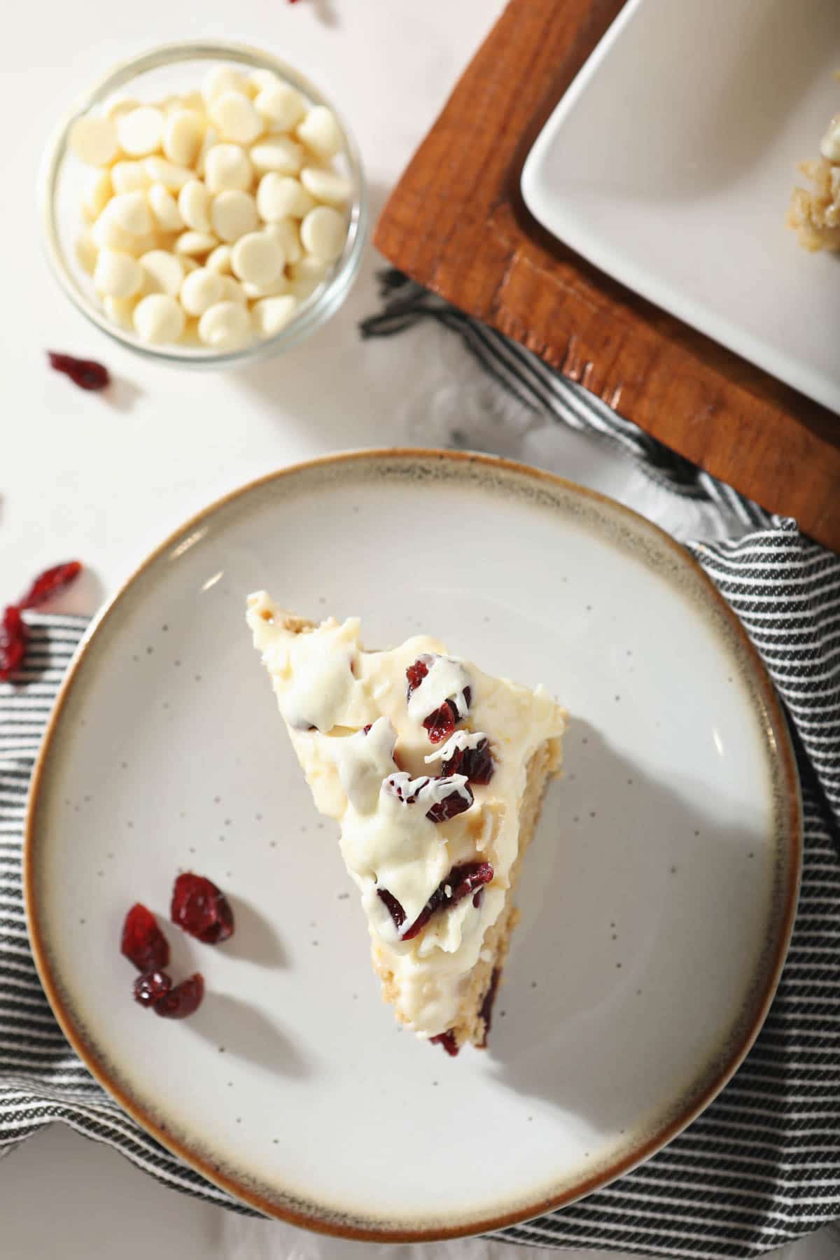 white plate with sourdough blondie beside cranberries