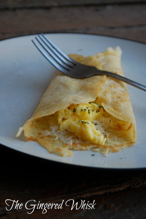 sourdough crepe on white plate filled with scrambled eggs