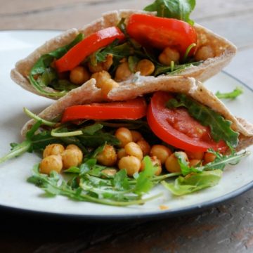 two fried Chickpea and Arugula Pitas stacked on white plate
