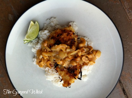 Current Alt: Coconut Crusted Chicken with Cashew Curry Sauce on white plate with limes