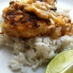 Coconut Crusted Chicken with Cashew Curry Sauce on white rice with limes