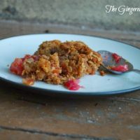 Apple Cranberry Crisp with Crispy Walnut Topping on a white plate with a spoon