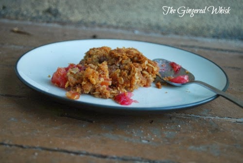 Apple Cranberry Crisp with Crispy Walnut Topping on a white plate with a spoon