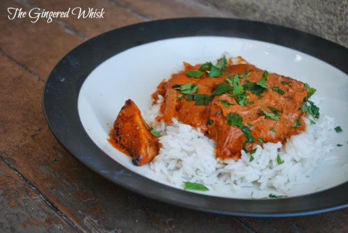 chicken tikka masala on plate with rice and topped with chopped cilantro