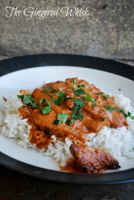 close up of chicken tikka masala on top of white rice